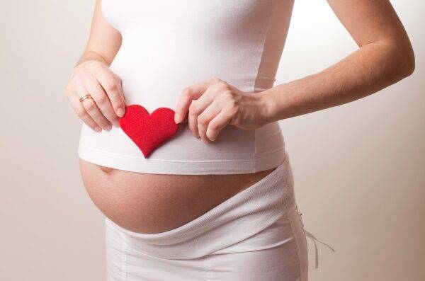 pregnant-woman-put-a-toy-heart-to-his-stomach