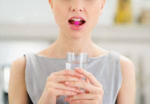 closeup-on-young-woman-with-pill-in-mouth